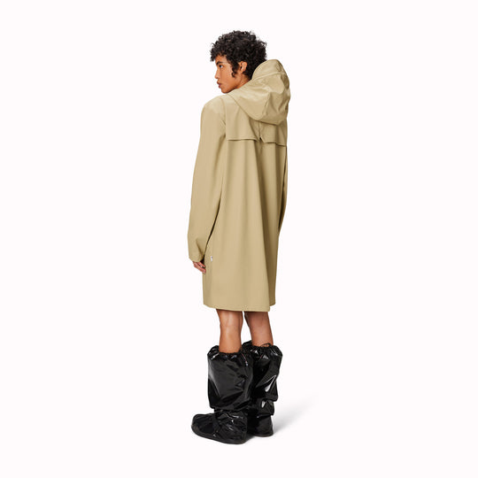 contemporary unisex rain jacket from Danish Outerwear and Lifestyle company Rains. This long Sand coloured rain jacket is characterized by a minimal silhouette in a long design.