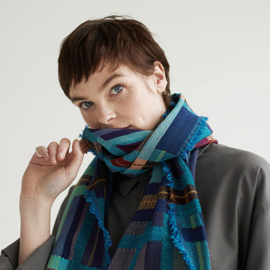 The Sedge Aqua lambswool scarf by Wallace and Sewell showcases the intricate craft of textile design, blending traditional techniques with modern aesthetics.