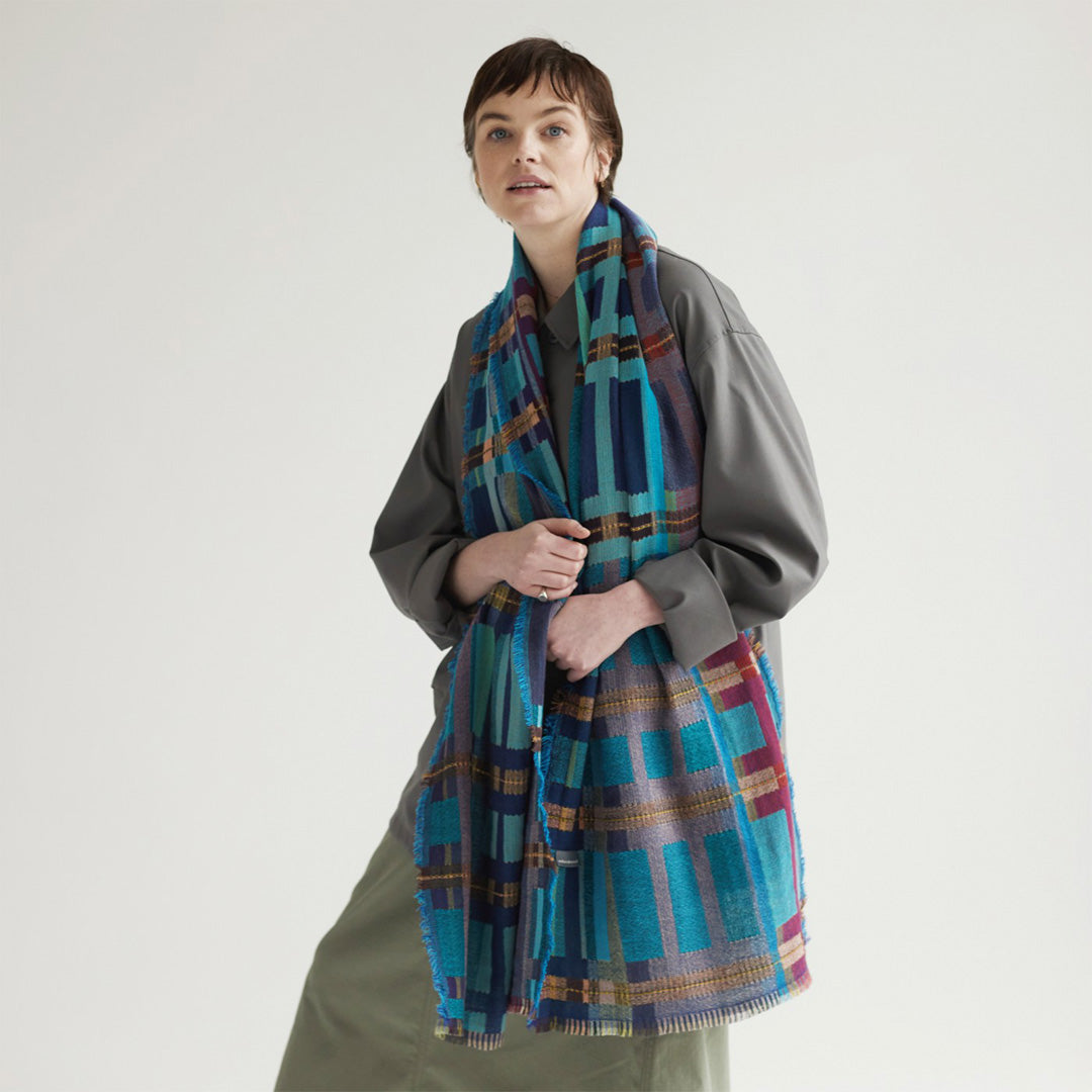 The Sedge Aqua lambswool scarf by Wallace and Sewell showcases the intricate craft of textile design, blending traditional techniques with modern aesthetics.