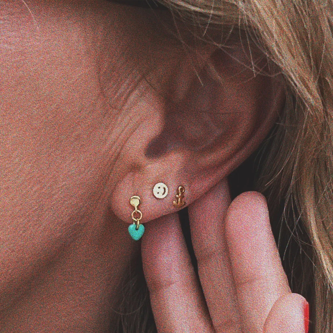 The Smiley gold-plated ear stud is an earring that spreads smiles and joy among your jewellery! Detail.