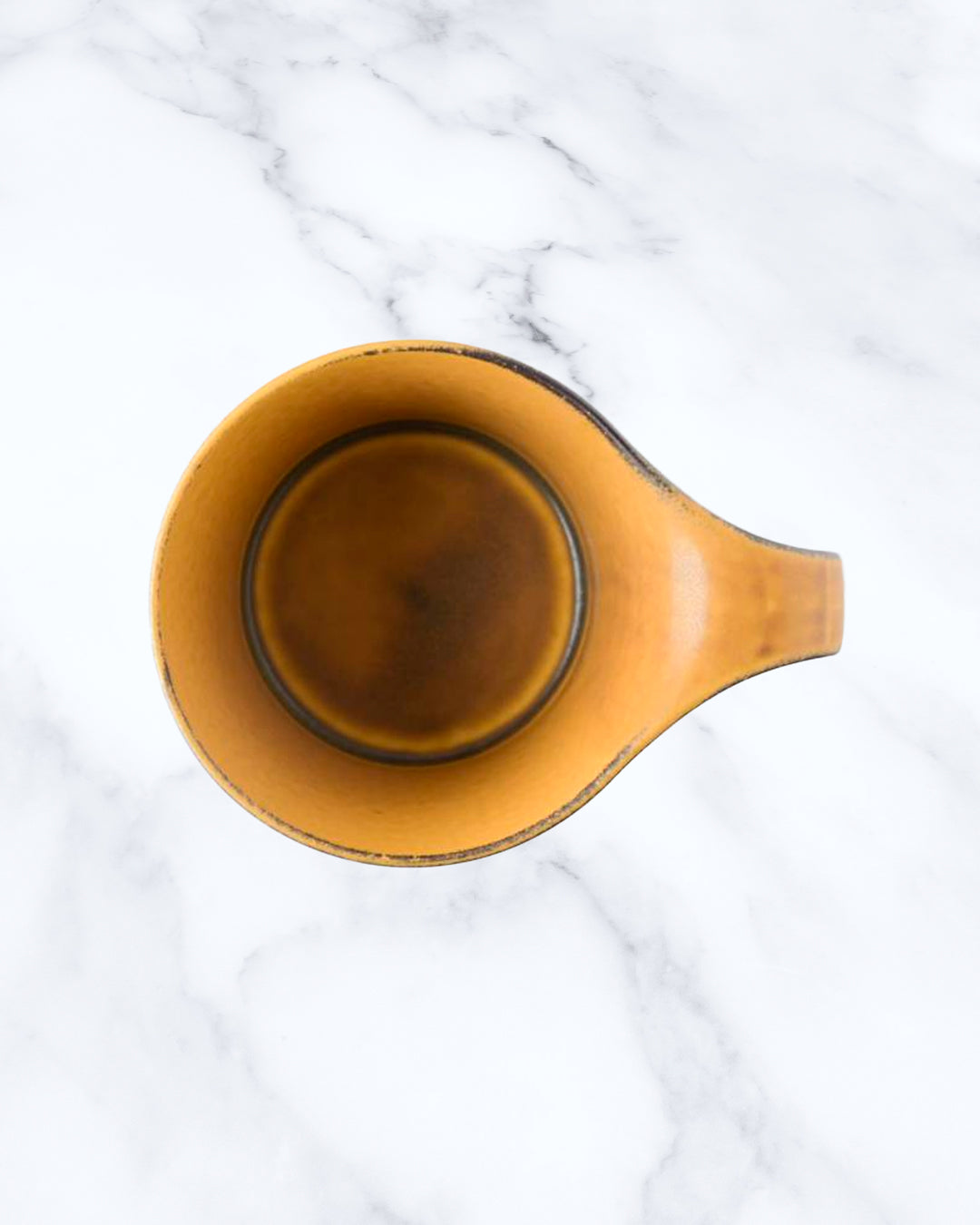 The Stamug is a porcelain mug with 150ml capacity for tea or shorter coffee drinks. Finished in a matt mustard glaze mixed with earthy brown tones.