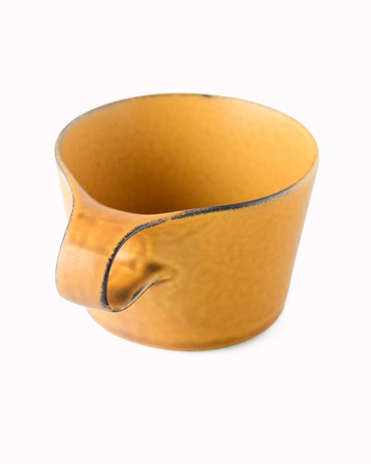 The Stamug is a porcelain mug with 150ml capacity for tea or shorter coffee drinks. Finished in a matt mustard glaze mixed with earthy brown tones.