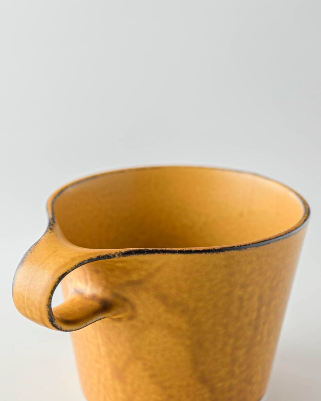 The Stamug is a porcelain mug with a compact 250ml capacity. Finished in a matt mustard glaze mixed with earthy brown tones. This glaze has natural variations in tone.
