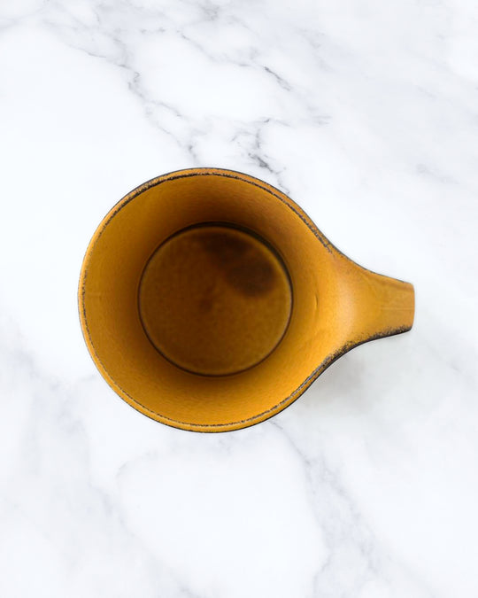 The Stamug is a porcelain mug with a compact 250ml capacity. Finished in a matt mustard glaze mixed with earthy brown tones. This glaze has natural variations in tone.