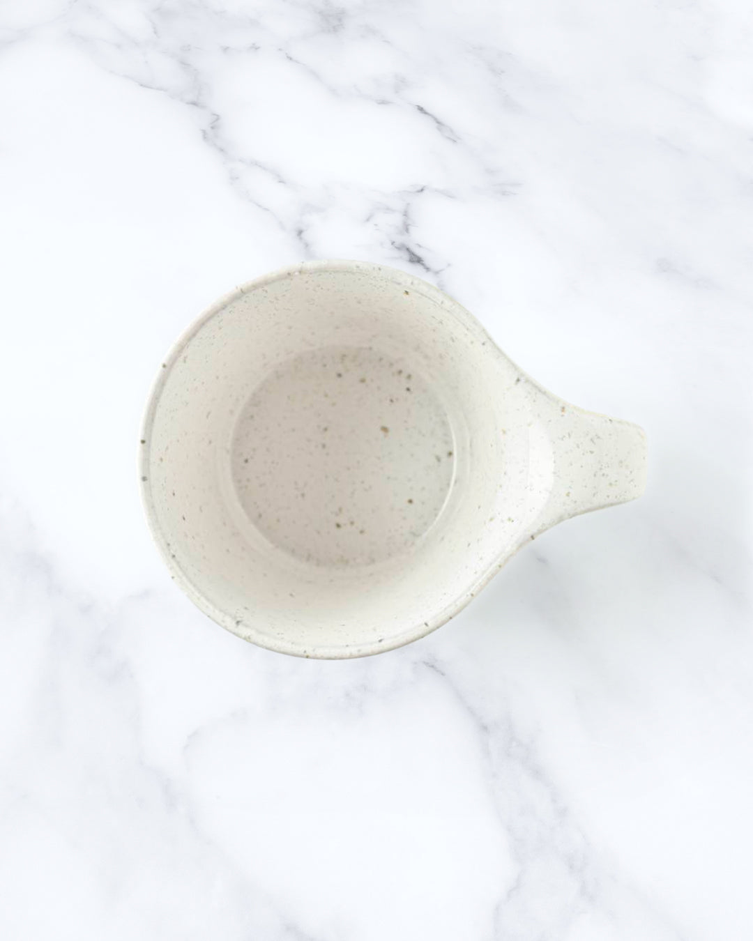 The Stamug is a porcelain mug with a compact 250ml capacity, finished in a white kiln gloss glaze with a soft slightly speckled finish.