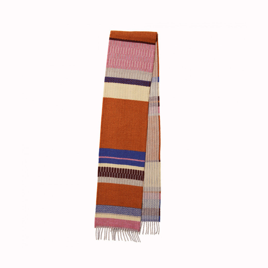 As Worn - The Strathay Amber Lambswool scarf by Wallace and Sewell is a 100% Merino Lambswool scarf in a colourful pattern of Ambers, Bubblegum Pink and Buttercup Yellow.