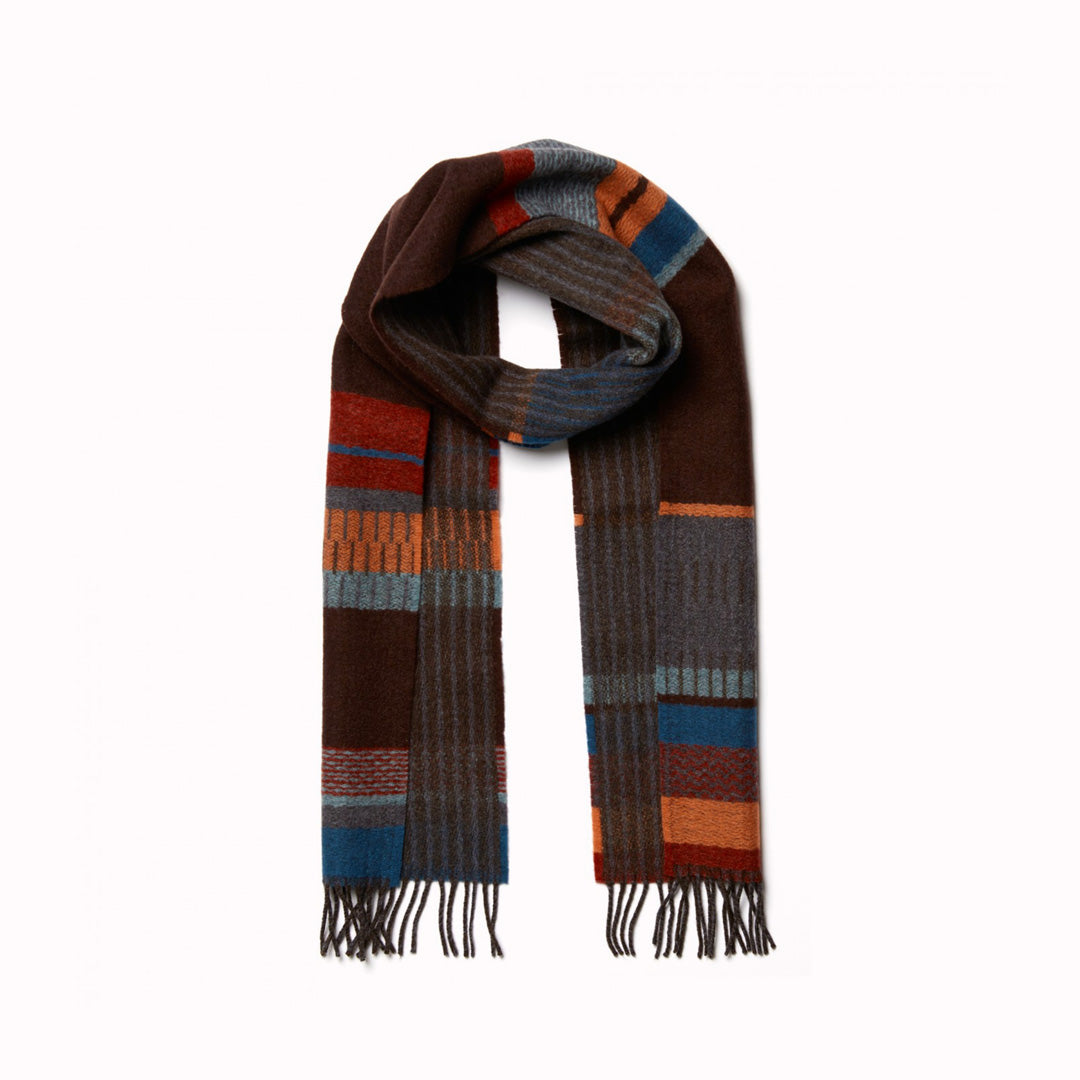 The Strathay Cinder Lambswool scarf by Wallace and Sewell is a 100% Merino Lambswool scarf displaying a deep peat palette and berry red tones to add warmth, while the burst of orange adds a lively touch.