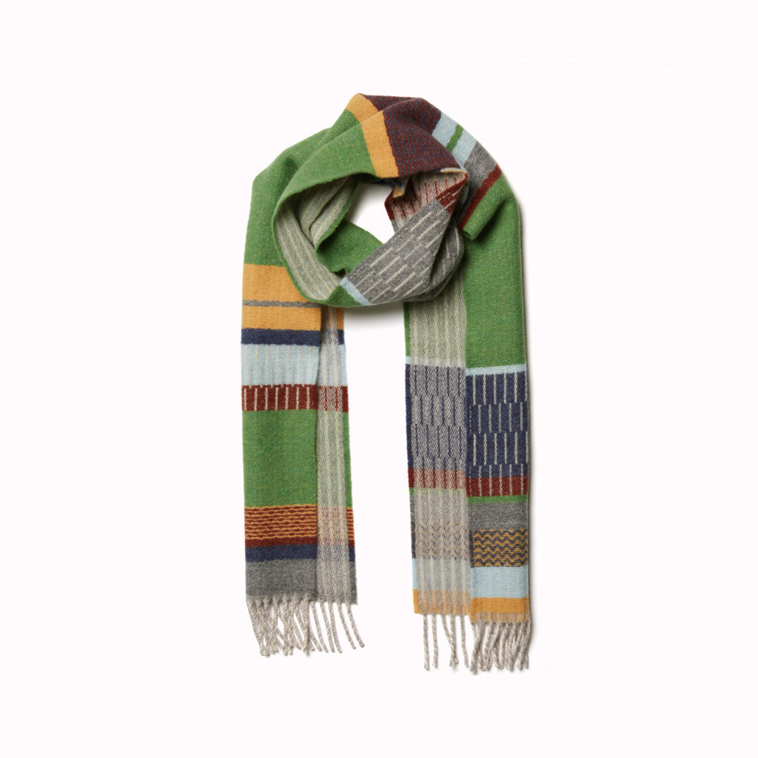 The Strathay Pea Lambswool scarf by Wallace and Sewell is a 100% Merino Lambswool scarf in a colourful pattern of pea greens, yellows and pale blues and greys. It is a testament to the intricate craft of textile design.