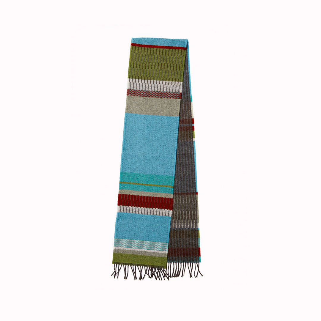 The Strathay Verdigris Lambswool scarf by Wallace and Sewell is a 100% Merino Lambswool scarf in a colourful pattern of verdigris blue, moss and orchard green, with a pop of dark red.