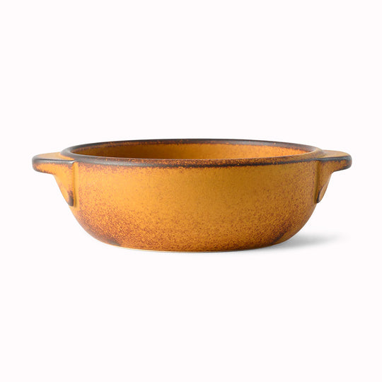 A hand finished Japanese contemporary over proof dish featuring handles and a sunflower yellow glaze.
