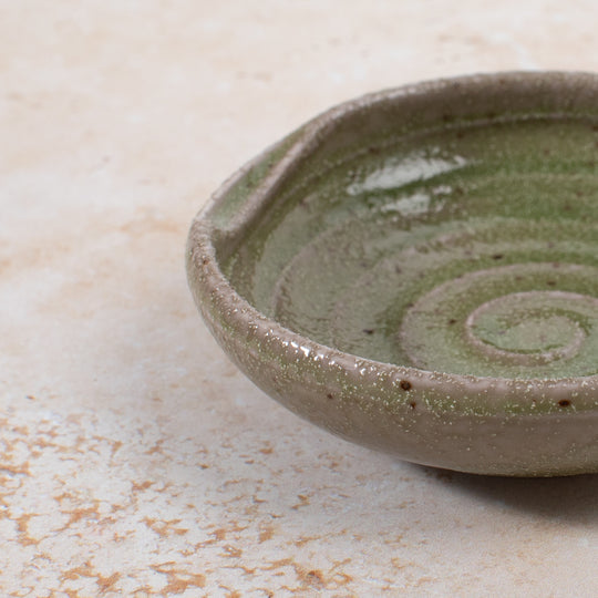 A mini serving dish made from Japanese mino ware, with Oribe green swirl pattern.