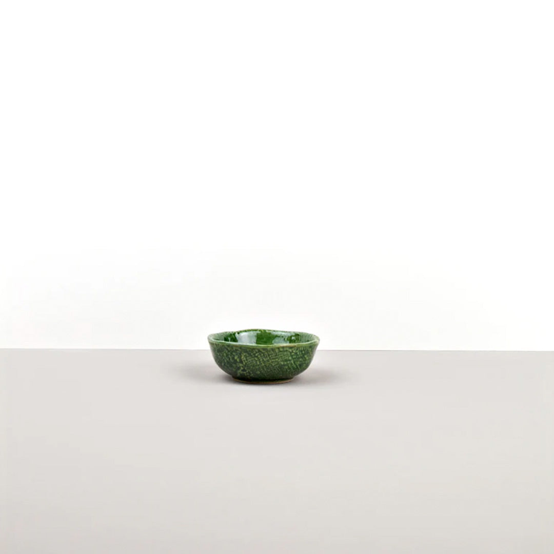 The Oribe Green Glaze features a mottled green with a yellow underglaze. Each piece has a unique dappled pattern determined by its position in the kiln during the firing process.