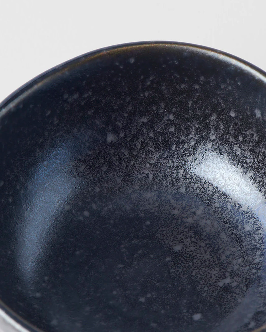 Matt Black Glaze Table Sauce Dish from Made in Japan, approximately 8.5cm with an irregular, organic shaping to the edge. Designed for soy sauce, dips or small condiments such as picked ginger.