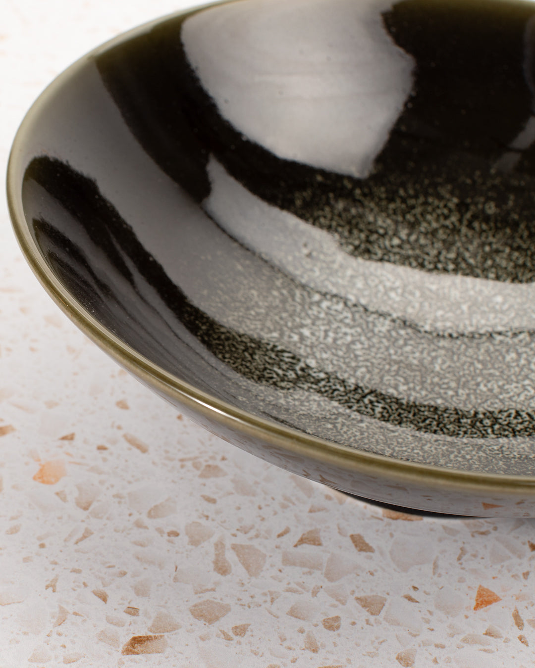 A stunning Japanese Mino ware Ramen bowl featuring a glossy dark green glaze with speckled cream feature glaze in the centre of the bowl.