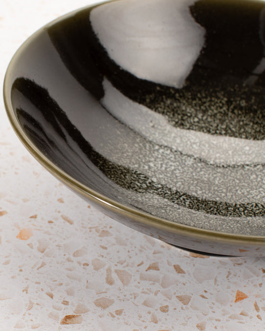 A stunning Japanese Mino ware Ramen bowl featuring a glossy dark green glaze with speckled cream feature glaze in the centre of the bowl.