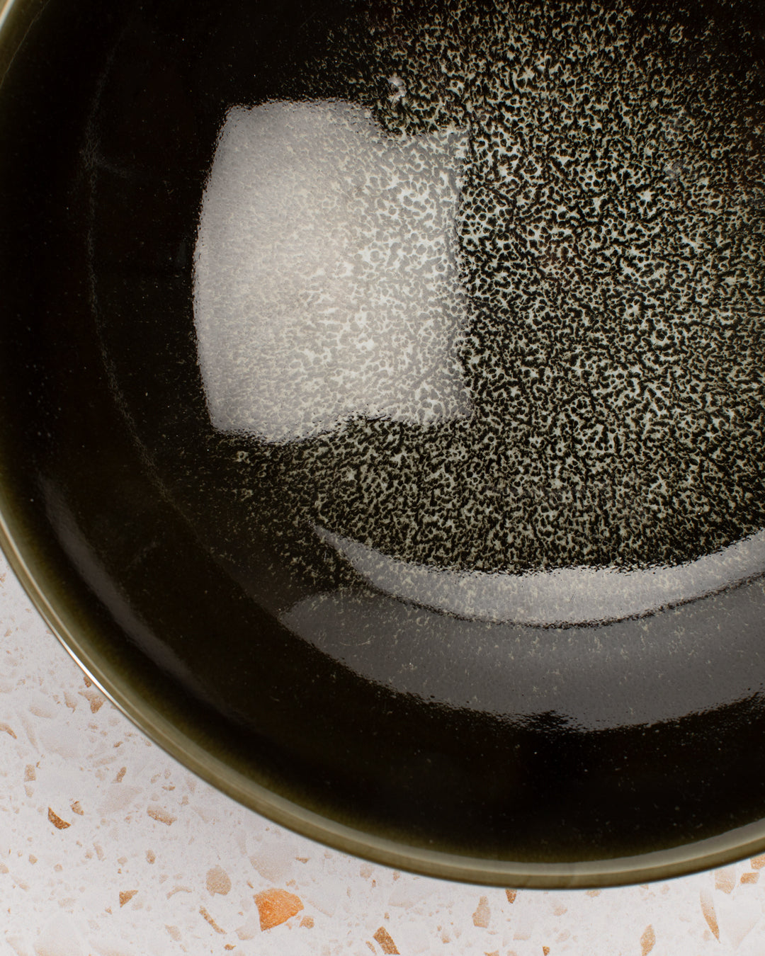 A stunning Japanese Mino ware Ramen bowl featuring a glossy dark green glaze with speckled cream feature glaze in the centre of the bowl.