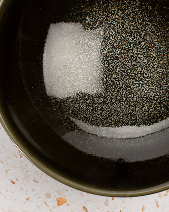 A stunning Japanese Mino ware Ramen bowl featuring a glossy dark green glaze with speckled cream feature glaze in the centre of the bowl.