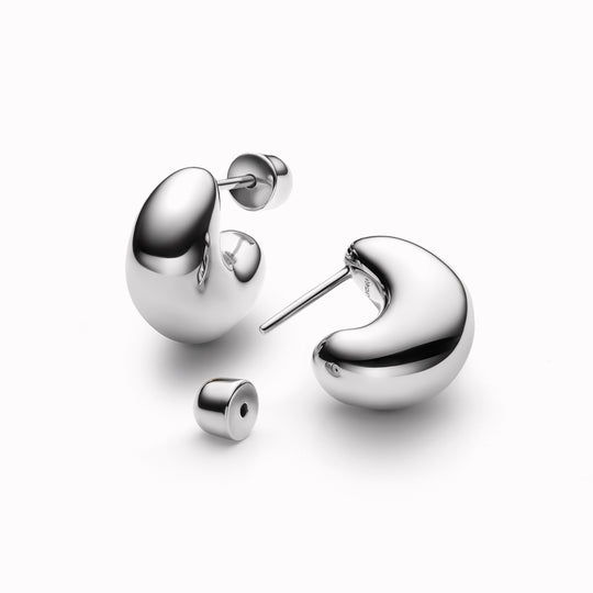 The Tryvann Pillow earring is designed in Denmark and skilfully crafted in 925 recycled sterling silver and plated with either White Rhodium or 18ct Gold, It is a chunky half-hoop earring that is Nickel free and hypoallergenic.