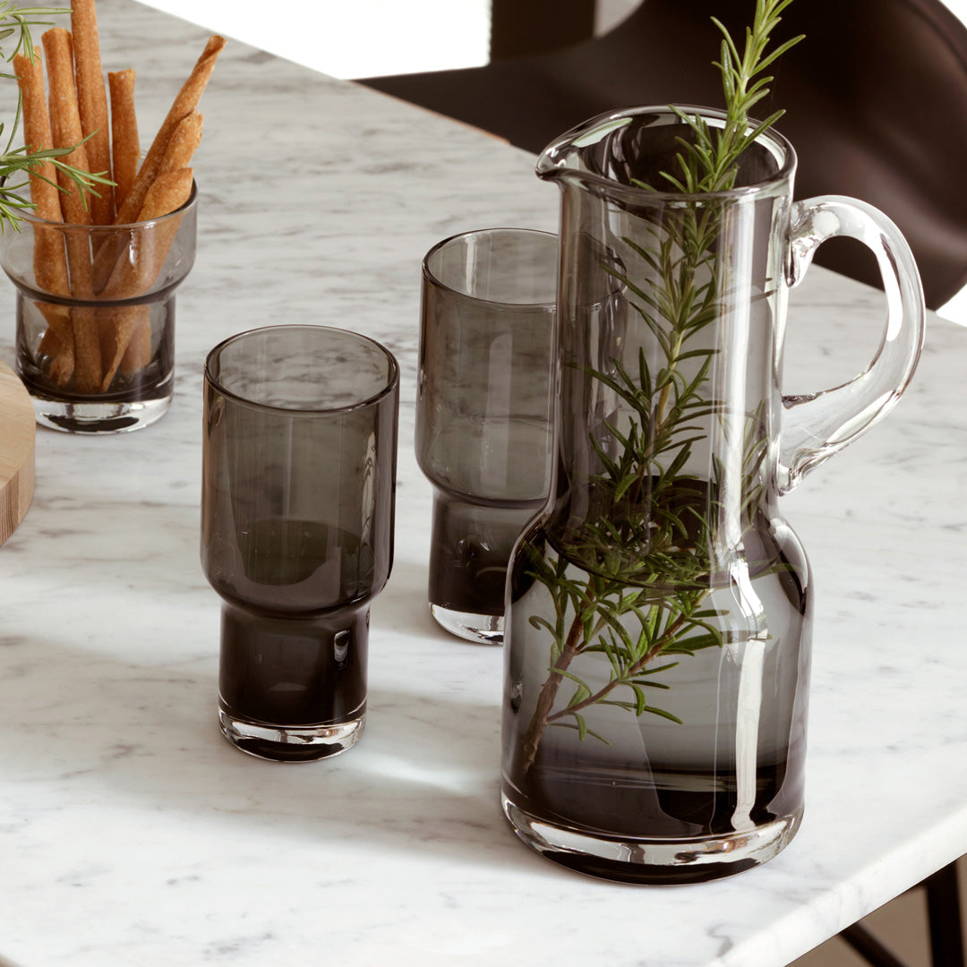 The Utility Jug is a hand made product and features a hand applied handle and hand formed spout. The edge is melted to achieve a thick soft rim and the spout is shaped by hand using a wooden tool. The handle is gathered from molten glass and applied while the glass is still malleable.