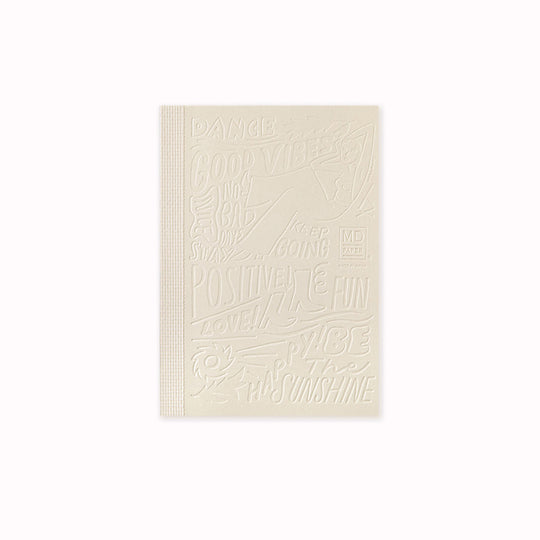 This A6 plain paper notebook has an off white cover embossed with some ace artwork by WALNUT featuring a female figure lounging amid positive quotes such as 'Be The Sunshine'.  The MD paper logo is also emboss