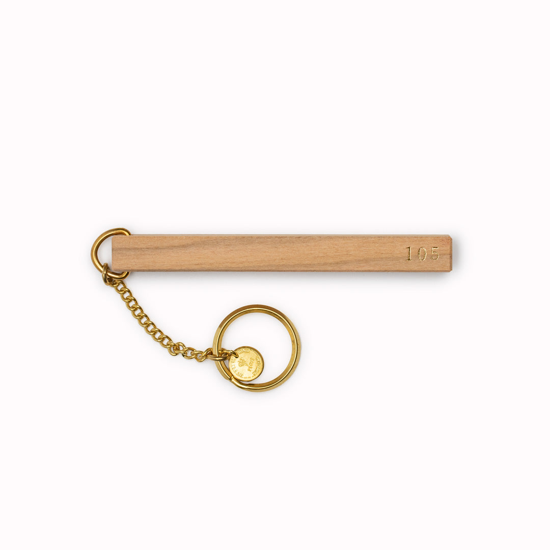 wooden hotel room keyring is crafted from solid cherry wood and brass, measuring L.95 mm and W.8 mm. It is proudly made in Japan and should not be cleaned with chemicals as a natural patina will develop over time.