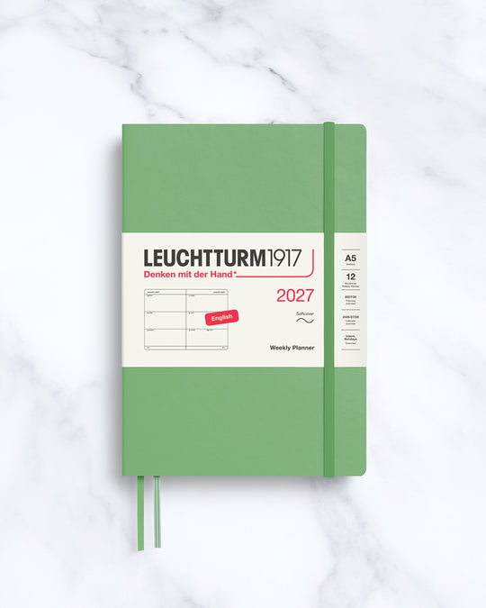 This A5 softcover yearly planner showcases 12 months of weekly layouts, including phases of the moon and international holidays.