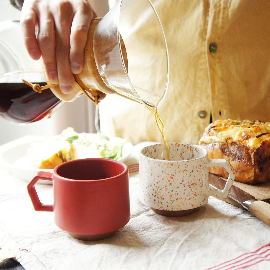 Compact and Easy to hold and stackable for easy storage. This Splash mug has a mixture of orange, yellow, and blue onto a white base with an unglazed base. They are sturdy and comfortable to hold with a unique silhouette.