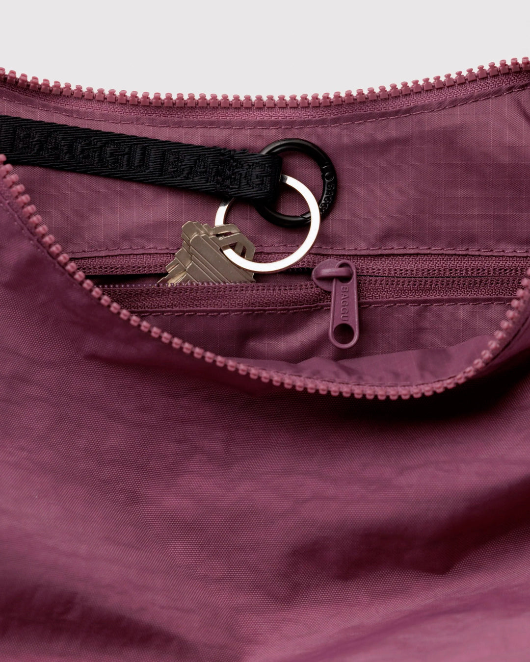 Made from recycled heavyweight nylon with a ripstop lining, it holds its form while staying lightweight. The strap adjusts to wear crossbody or over the shoulder, shifting the silhouette depending on how it’s carried.