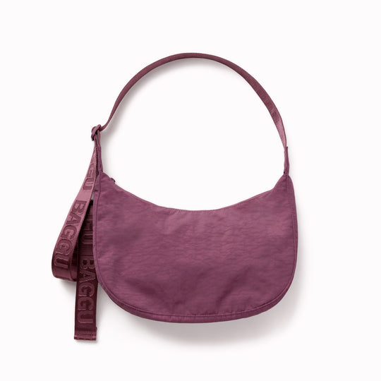 Made from recycled heavyweight nylon with a ripstop lining, it holds its form while staying lightweight. The strap adjusts to wear crossbody or over the shoulder, shifting the silhouette depending on how it’s carried.