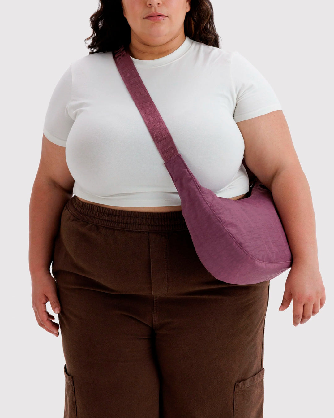 Made from recycled heavyweight nylon with a ripstop lining, it holds its form while staying lightweight. The strap adjusts to wear crossbody or over the shoulder, shifting the silhouette depending on how it’s carried.