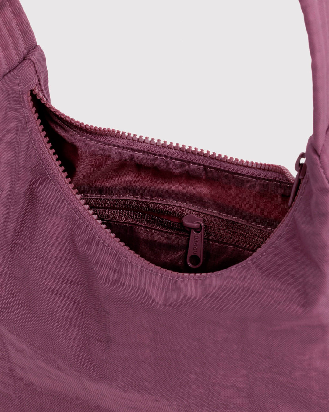 Made from recycled heavyweight nylon with a recycled ripstop lining, it balances durability with a lightweight feel.