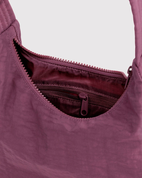 Made from recycled heavyweight nylon with a recycled ripstop lining, it balances durability with a lightweight feel.