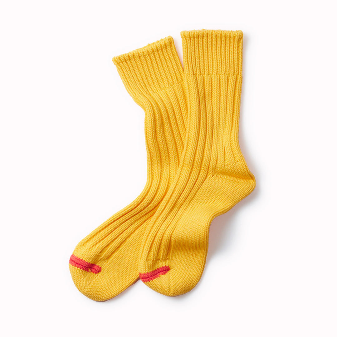 Premium Japanese cotton chunky organic cotton ribbed socks that are knitted on a traditional, non computerised knitting machine. Thick and comfortable with long-lasting quality, with excellent breathability due to the chunky rib stitch.  Yellow socks with a contrasting stripe across the toe.