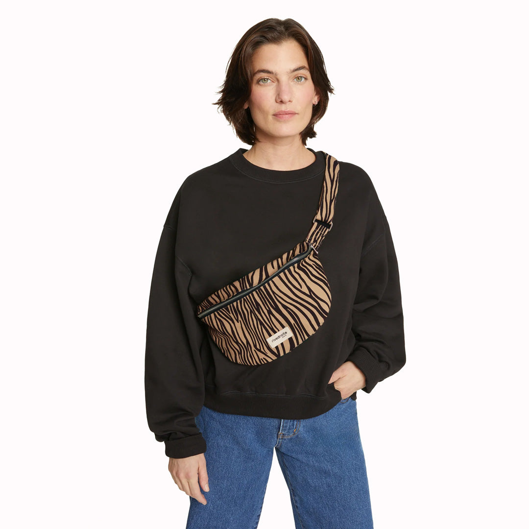 The Custine Belt Bag in Zebra Print is a stylish and practical accessory crafted from upcycled fabric. Designed by Rive Droite, a brand known for its commitment to sustainable fashion