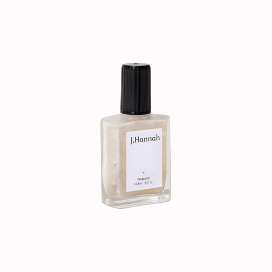 Akoya nail polish by J.Hannah is their only transparent shade, inspired by the opulence of silk, gold leaf and the delicate lustre of oysters. Neutral with a subtle golden sheen. Sideways View of Bottle