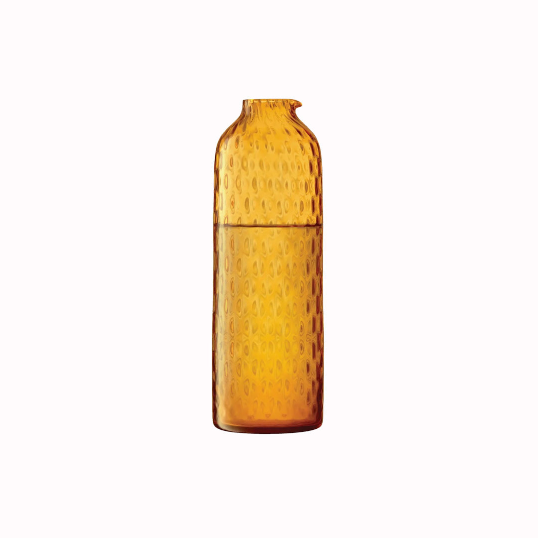 The Dapple Carafe is a lattice textured bottle shaped carafe made from coloured amber yellow mouth-blown glass. The Dapple Carafe features a beautiful undulating textured surface that is inspired by dappled sunlight on water.