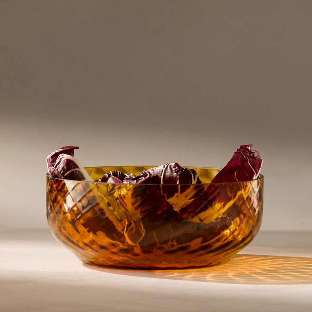 Lifestyle Image - The Dapple Bowl is a lattice textured small serving or fruit bowl made from coloured amber yellow mouth-blown glass. The Dapple Bowl features a beautiful undulating textured surface that is inspired by dappled sunlight on water.