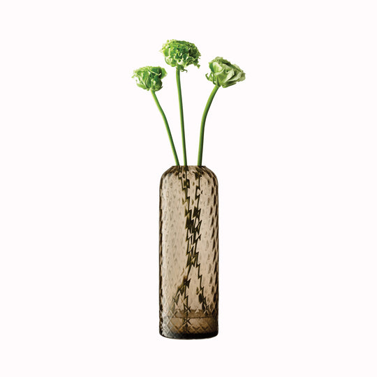 With flowers, Earth Brown - Dapple Vase is a contemporary, tall and slim shaped vase made from coloured brown mouth blown glass. The Dapple Vase features a beautiful undulating textured surface that is inspired by dappled sunlight on water.