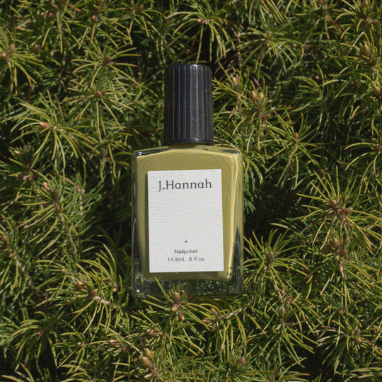 pictured on spruce tree branches. Eames nail polish by J.Hannah is a chartreuse green inspired by the exploration of colour in midcentury works by designers such as Charles & Ray Eames. 