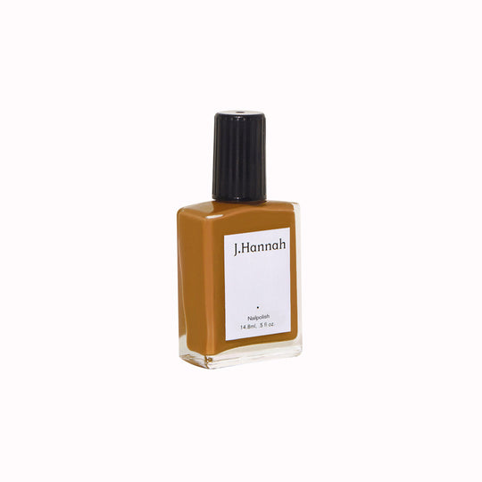 Angled Bottle View. Fauna nail polish by J.Hannah is a soothing ochre shade, drawing influence from warming and healing spices such ginger and turmeric.