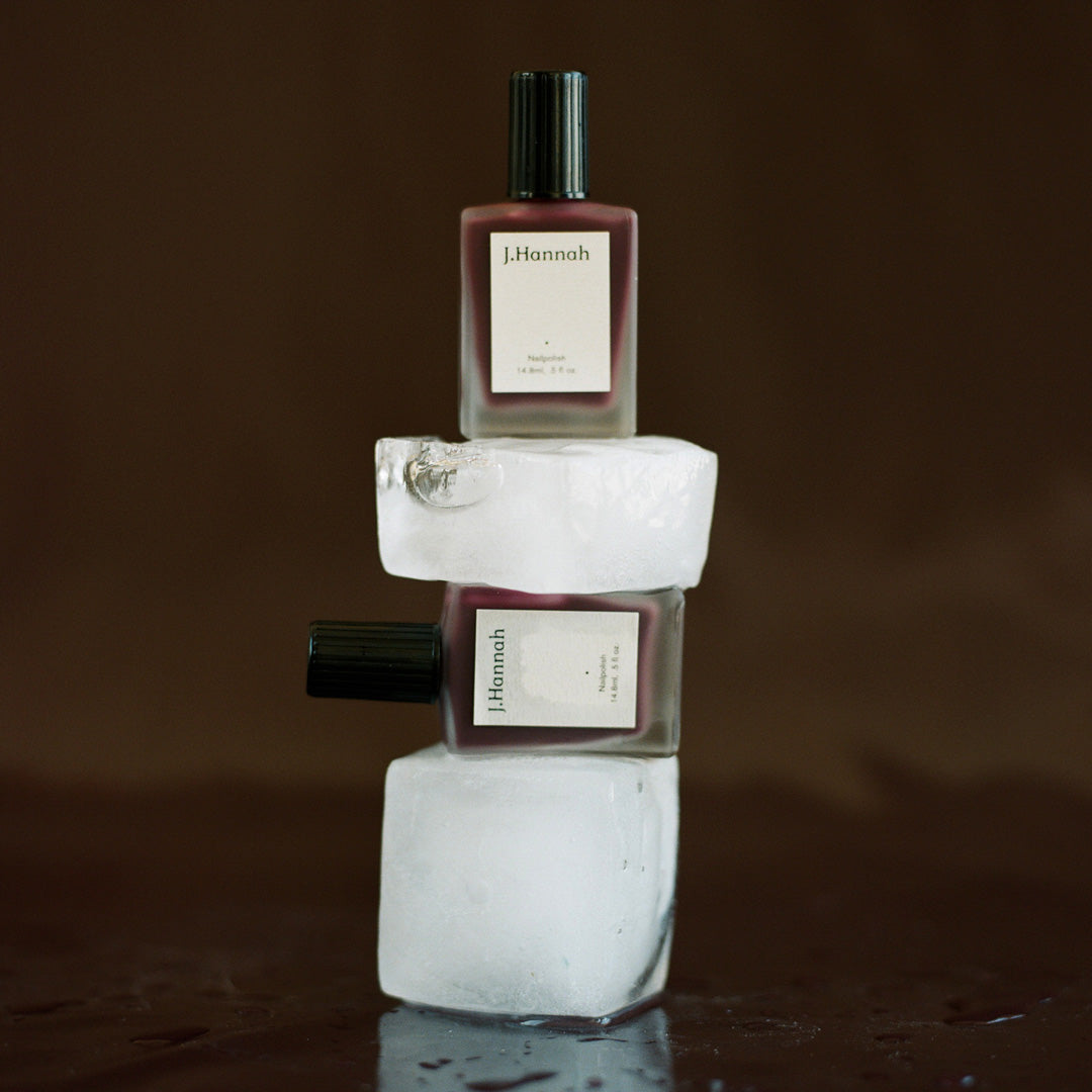 Collection of Bottles with Ice. Gamay nail polish by J.Hannah is a tinted red wine colour, inspired by the sheer shades of watercolours and wine stained teeth. An amethyst shade that deepens with multiple layers.