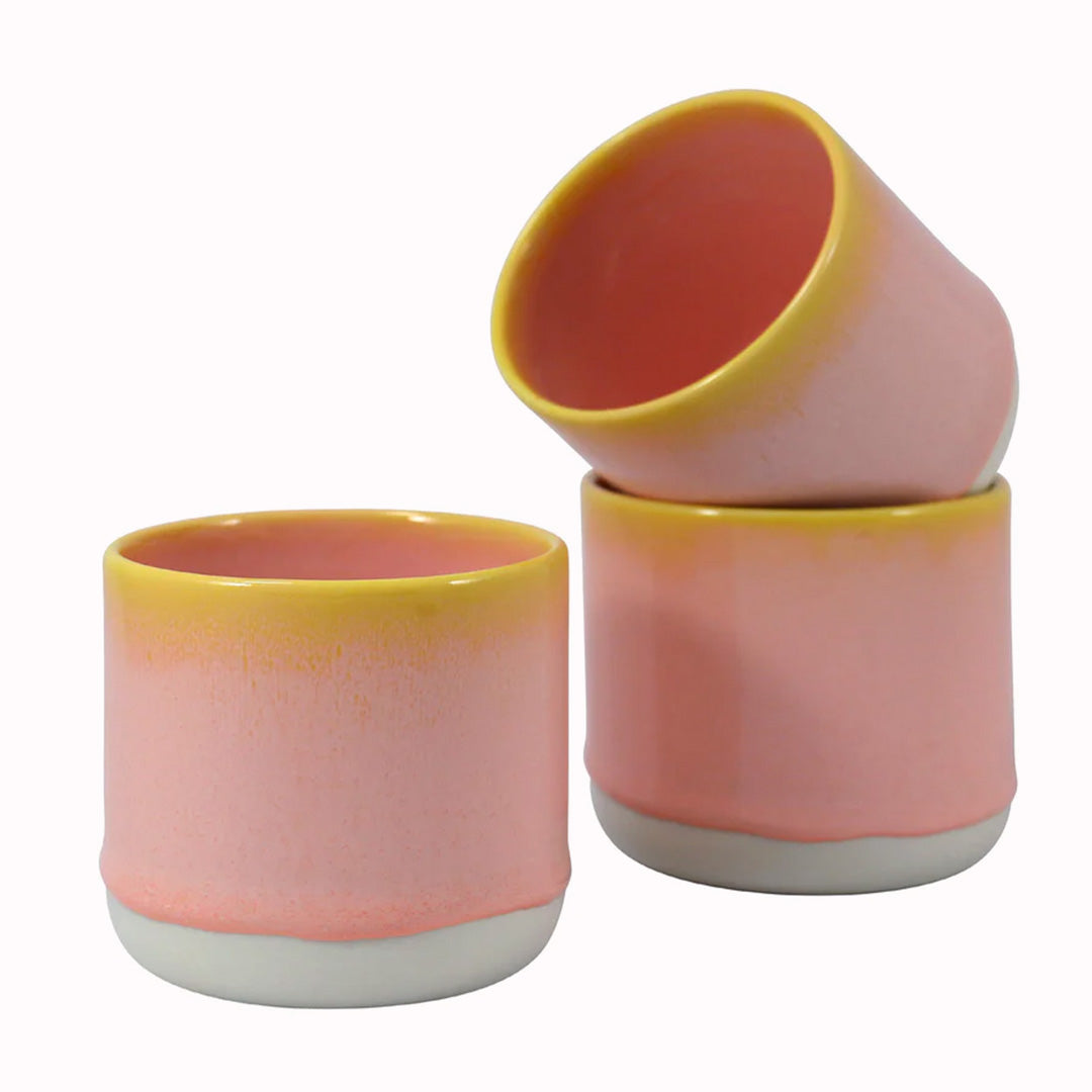 Collection of Pink Grapefruit mugs. The yellow rimmed, pink drip glazed Quench Cup is handmade in Denmark - meaning glaze colour and finish will never be exactly the same on any two items, but this is absolutely a part of their unique appeal.