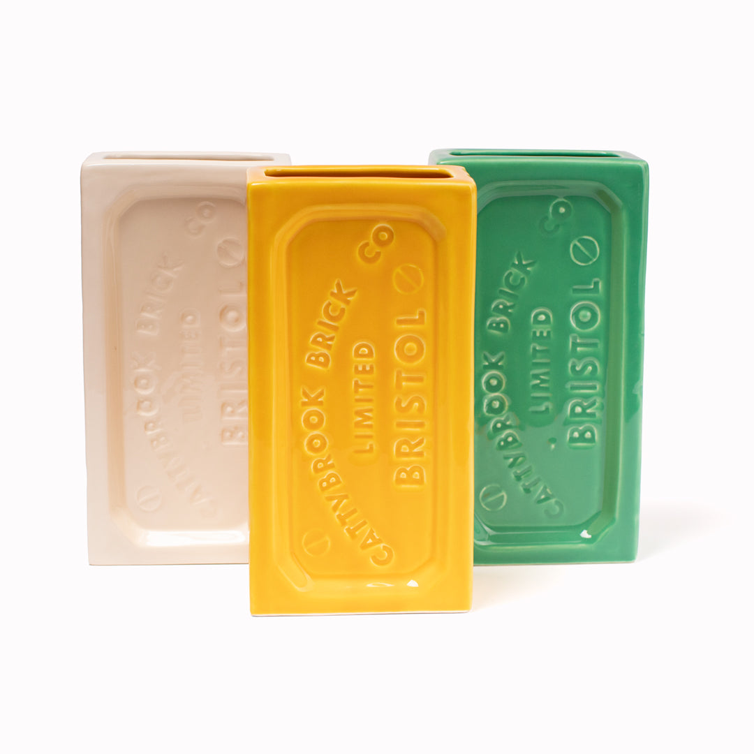 A ceramic vase in the shape of the classic Bristol Brick. Made by StolenForm, a concept brand that specialises in repurposing industrialised objects, transforming them into home accessories and giftware products. The Bristol bricks are watertight, perfect for flowers and plants, or can be used for office stationery or kitchen utensils. This shows the White, Yellow and Green colours.