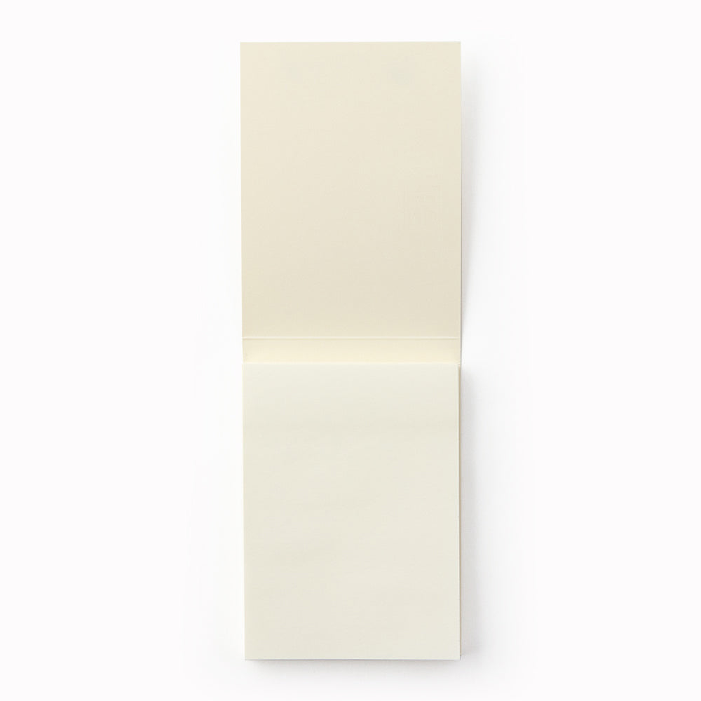 Showing plain pages. A7 memo pad with embossed off-white cover and plain sheets. Designed to work alongside the MD Paper notebook series, it uses the same quality paper and same plain layout so you can seamlessly add notes into pages in your MD Paper Plain notebook. It is sticky on one side, but you can write on both sides. 80 tear off pages.