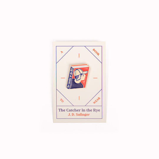 Enamel pin badge with backing board featuring an illustrative book cover interpretation of the modern American, coming of age, classic novel 'The Catcher In The Rye' by J.D. Salinger.