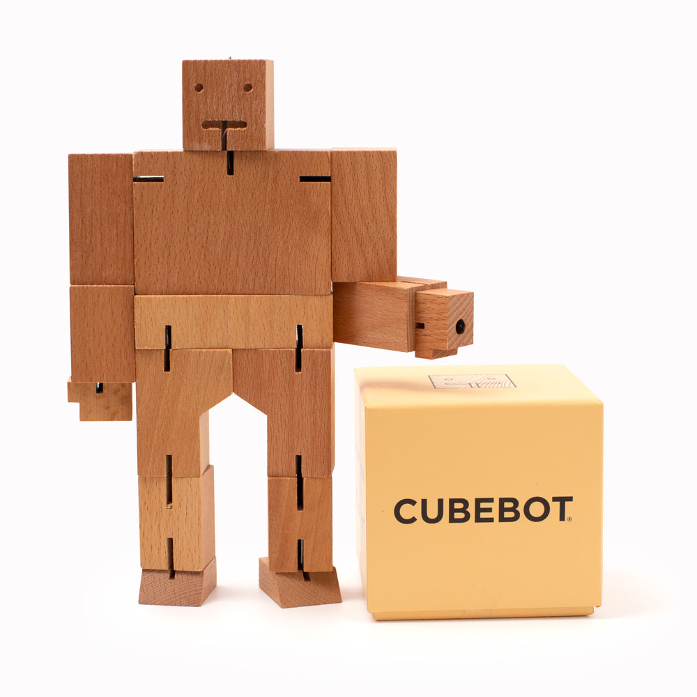 Cubebot is a fun wooden toy robot that folds out of a perfect cube shape. Part puzzle, part posable toy they are inspired by Japanese Shinto Kumi-ki puzzles and can be positioned to hold dozens of poses.   Made from Beech and elastic. Posable and decorative. 24 cm tall, 34 cm arm span