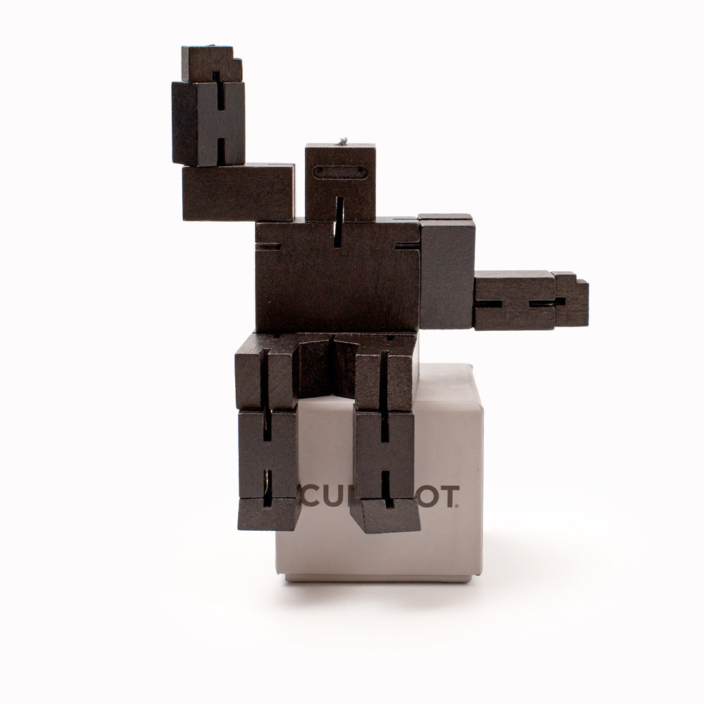 The black Cubebot by Areaware is a fun wooden toy robot that folds out of a perfect cube shape. Part puzzle, part posable toy they are inspired by Japanese Shinto Kumi-ki puzzles and can be positioned to hold dozens of poses.   Made from Beech and elastic, water based paint. Posable and decorative. 17 cm tall, 23.5 cm arm span.
