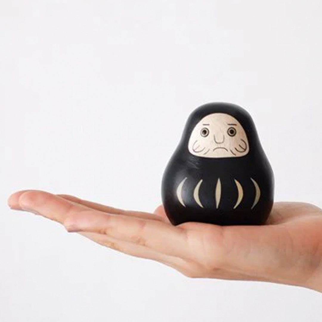 Daruma Doll Engimon handmade wooden figurine by T-Lab Japan, in hand.