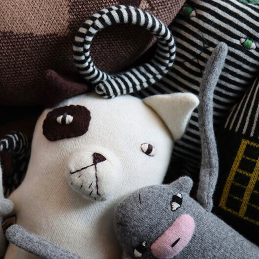 Digby is a super-soft doggo, from Donna Wilson's brilliant creatures collection lifestyle image. White with one brown ear and a matching brown eye patch, Digby likes chorizo sausages.