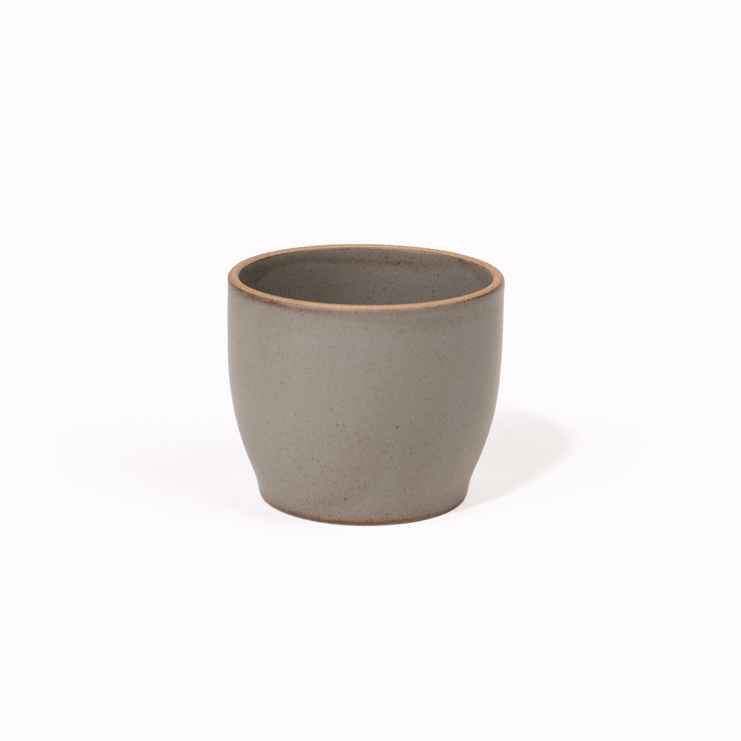 The 200ml Grey Nori Porcelain Tumbler is a Japanese manufactured small tea, coffee, or juice cup from Kinto. The porcelain has a tactile sloping side and smooth finish which feels pleasing in your hands. The glaze is a tasteful matt grey stone with raw porcelain edges in the Japanese style.
